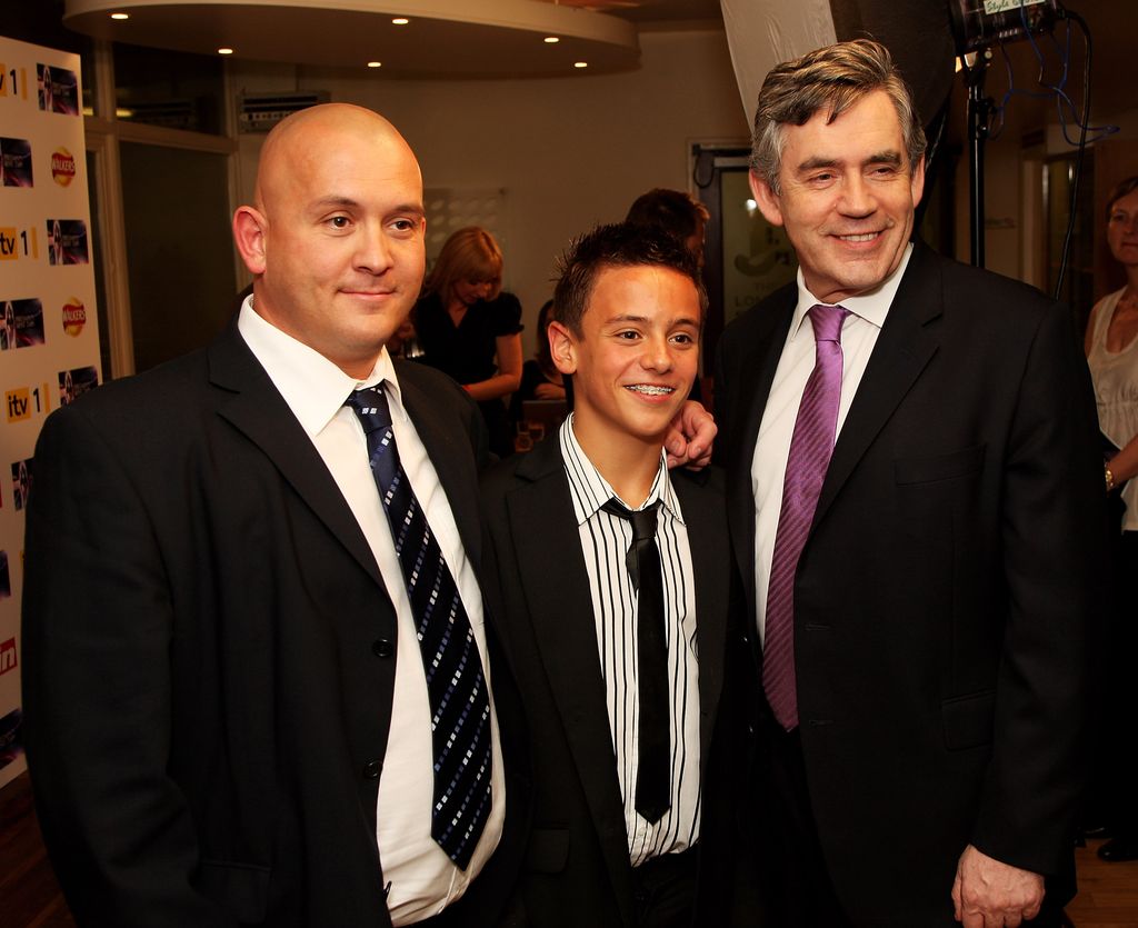 A young Tom Daley standing with his father and Gordon Brown