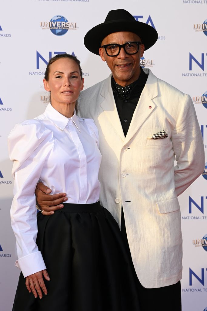 Jay Blades in a cream jacket and black hat with wife Lisa in a white shirt