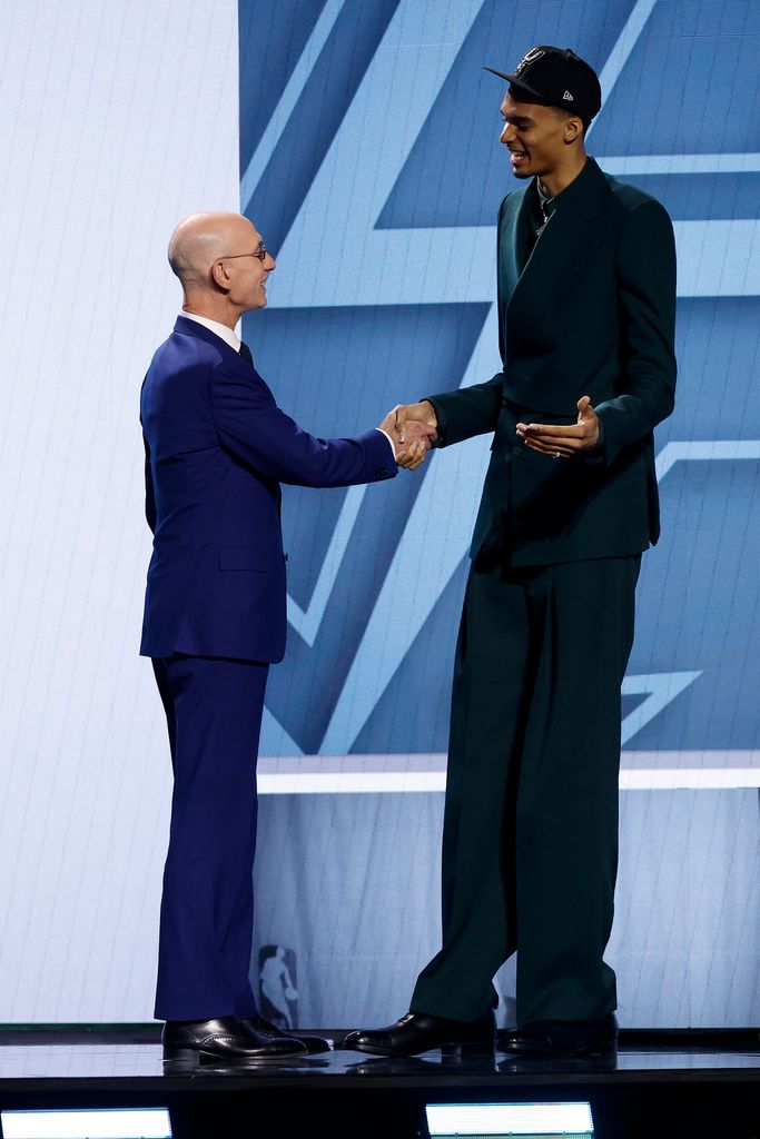 Victor Wembanyama (R) shakes hands with NBA commissioner Adam Silver (L) 