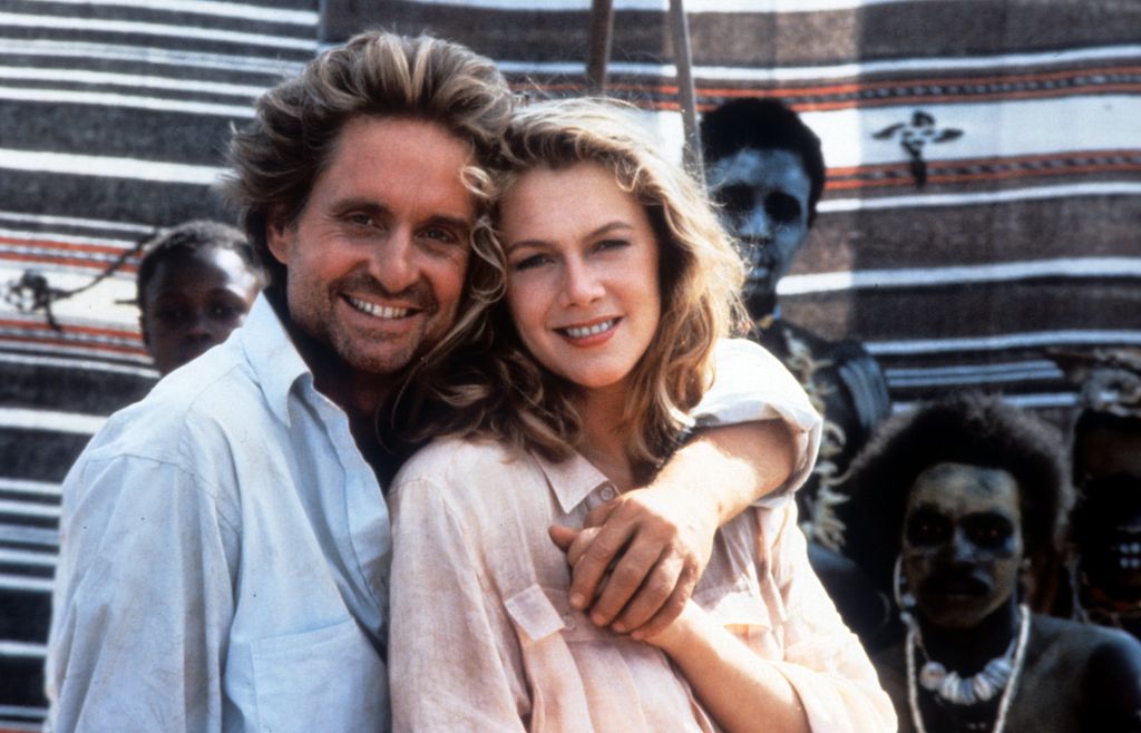 Michael Douglas and Kathleen Turner with their arms around each other 