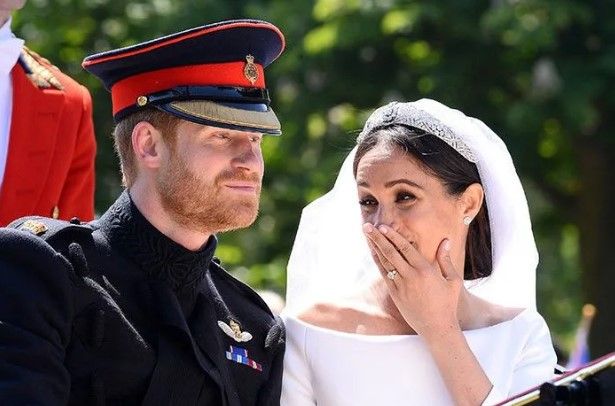 Meghan Markle covering her mouth as she laughs on her wedding day