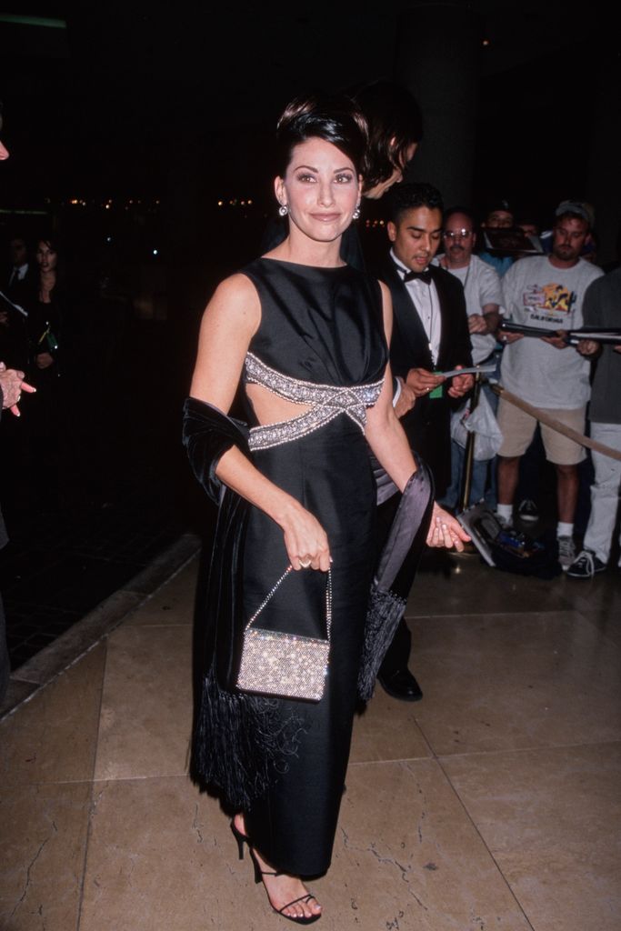 American actress Gina Gershon, wearing a black cut-out dress with sparkling trim