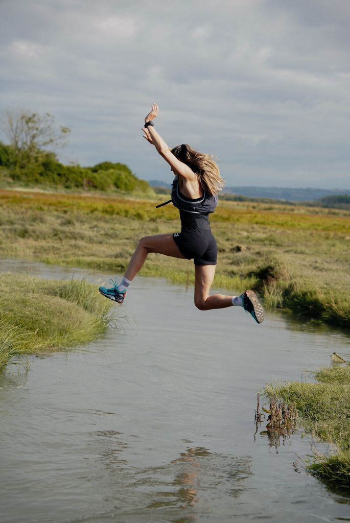 woman leaping over a river