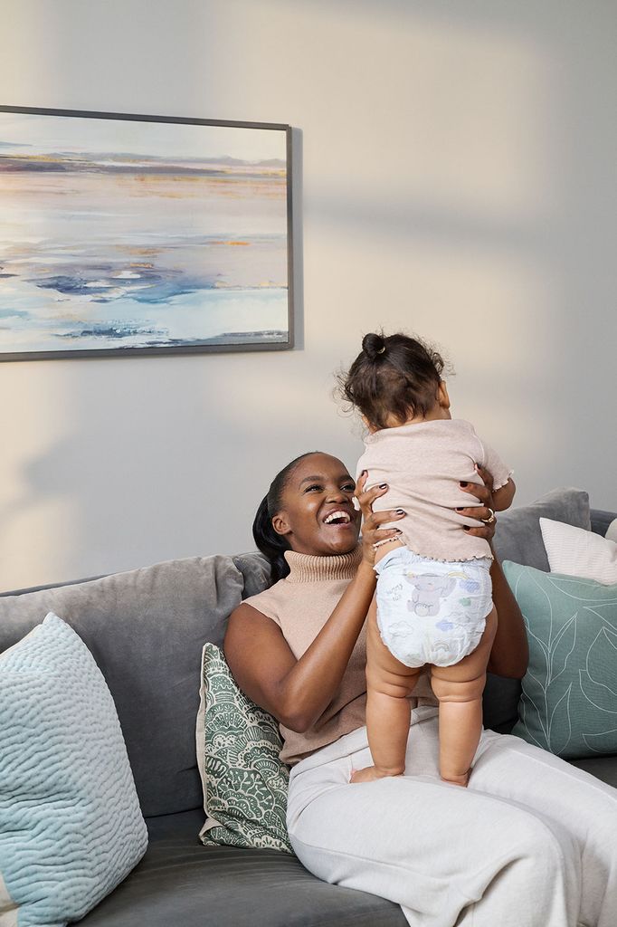 mother sat on sofa with baby daughter