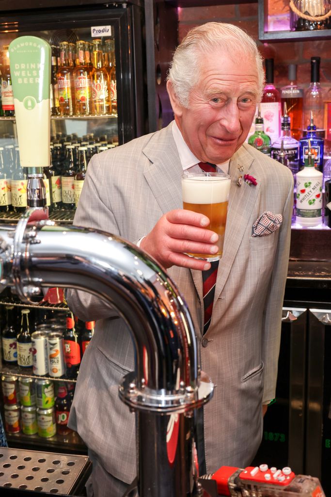 A photo of King Charles holding a beer 