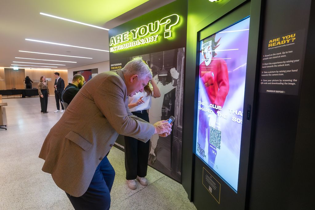 Man leaning close to a screen taking a photo of himself 