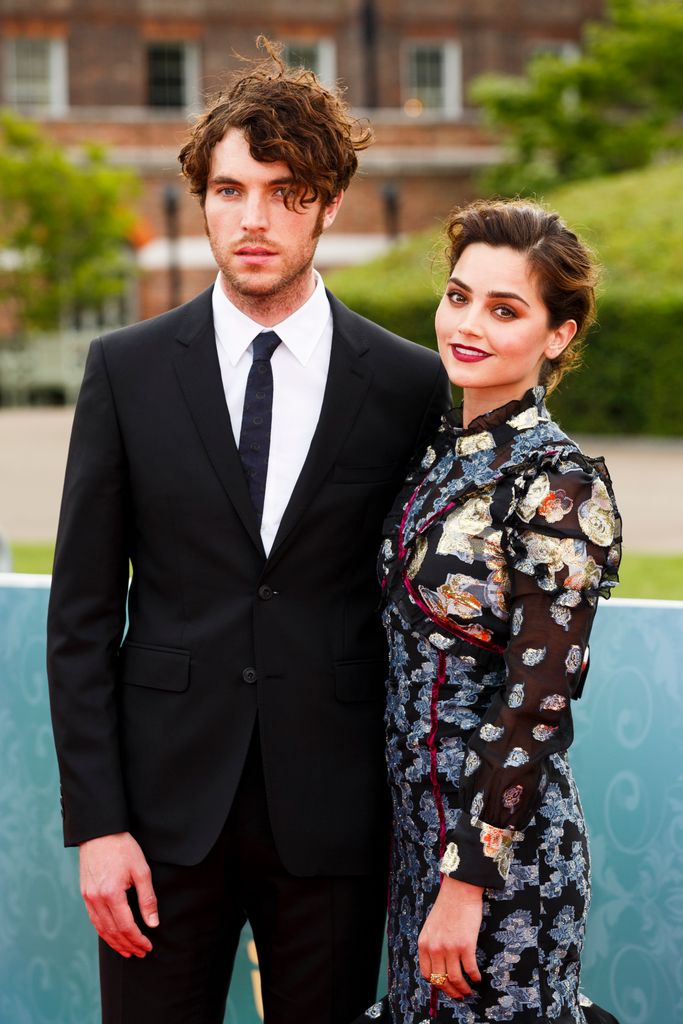 Tom Hughes in a black suit with Jenna Coleman