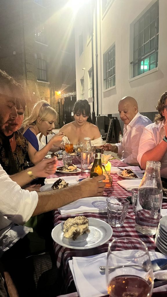 photo of daisy lowe sitting at table with family on wedding day