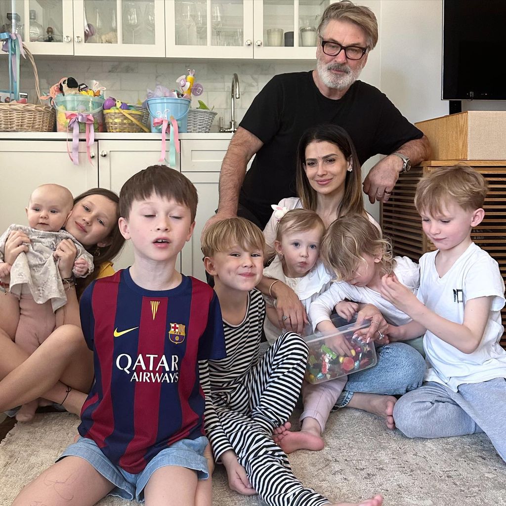 Alec with his wife and seven children in gorgeous neutral kitchen