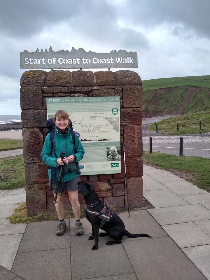 woman with her dog dressed in walking gear about to take on a coast to coast hike