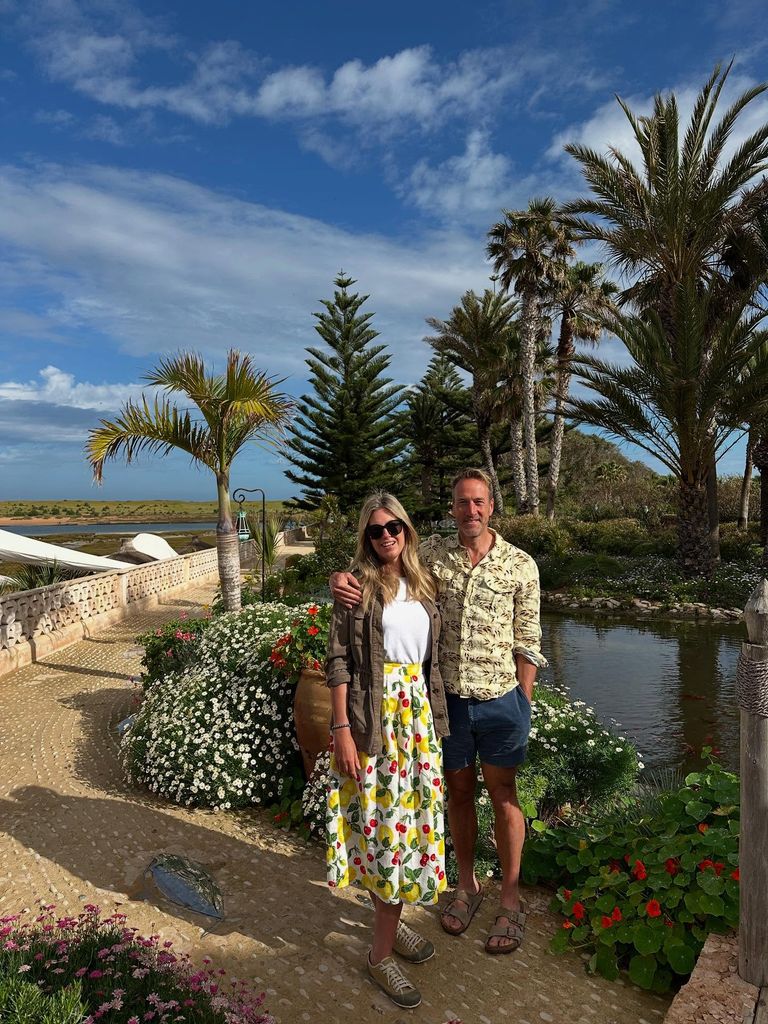 couple on holiday posing by date trees 
