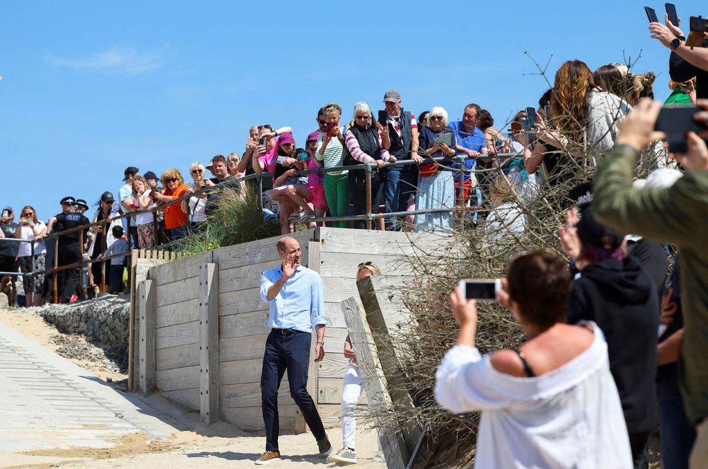 Prince William, Prince of Wales, waves to well-wishers as he arrives to visit to Fistral Beach