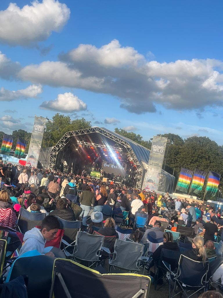 People watching a performance on stage in the sunshine