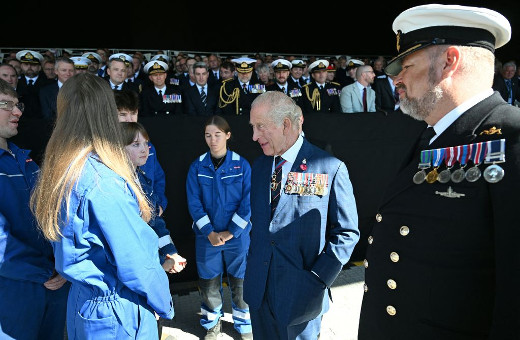 The King talked with young people in blue jumpsuit uniforms
