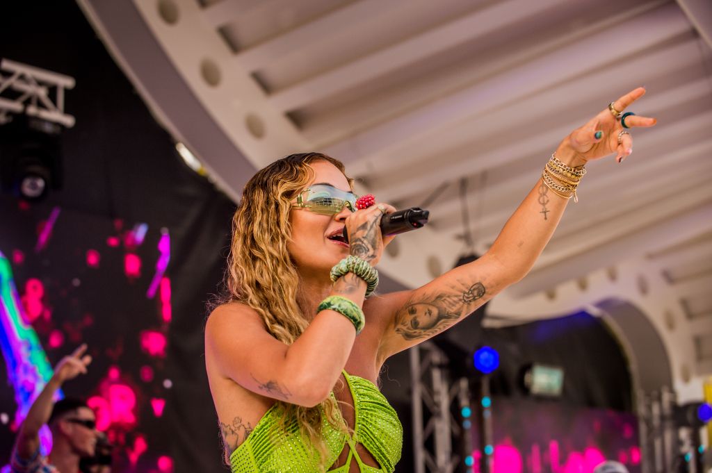 Rita Ora in green bejewelled halterneck swimsuit singing 