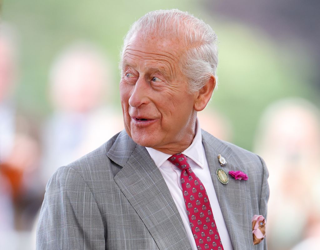 King Charles wearing grey suit and red tie