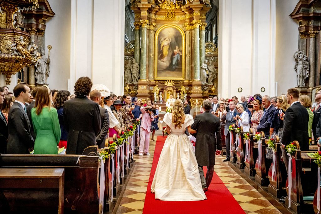 Countess Felicitas of Hartig walking down the aisle with her father at her religious wedding with Prince Johann-Wenzel of Liechtenstein