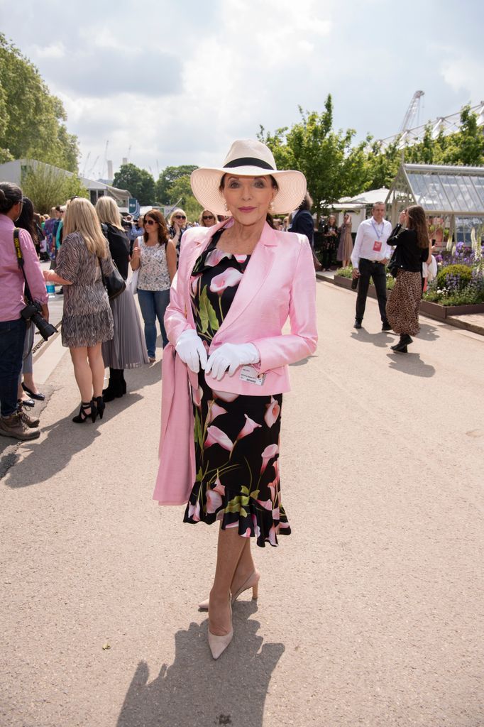 Joan Collins at RHS Chelsea Flower Show in black floral dress and pink blazer