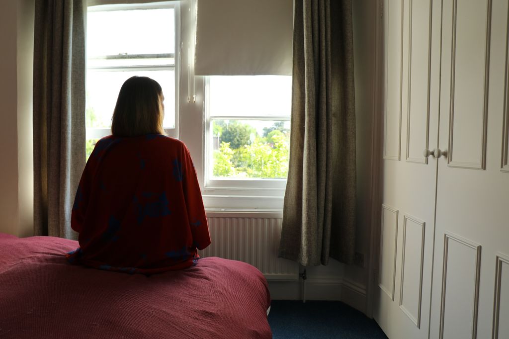 Rear view of a  woman seated on the bed