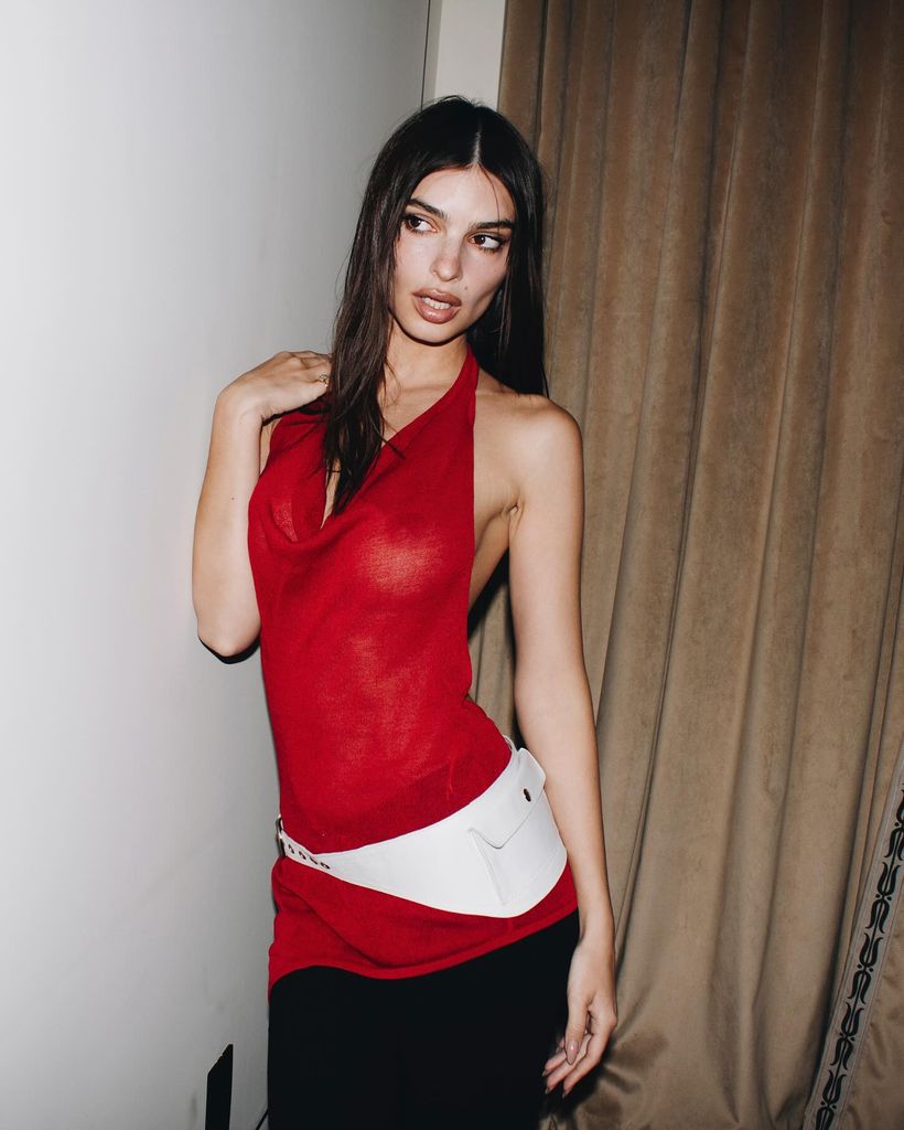 Emily Ratajkowski wears her handyman beltbag and a red halterneck top
