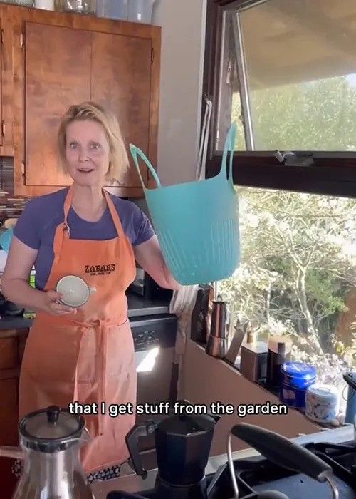 cynthia nixon holding basket inside her kitchen