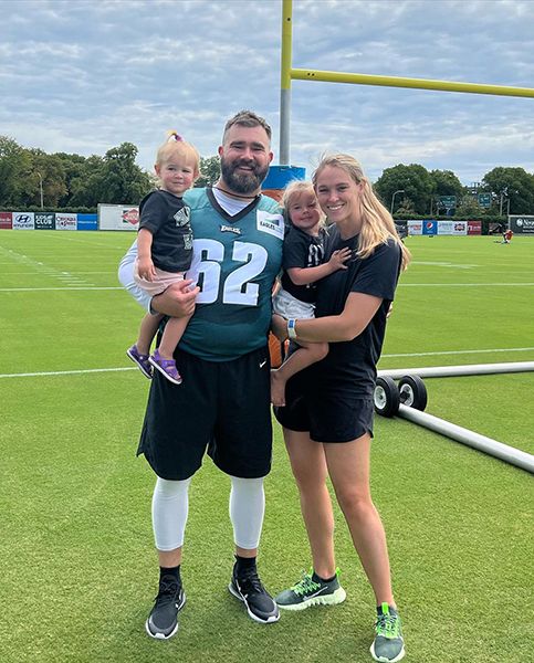 jason kelce posing on field with wife and daughters
