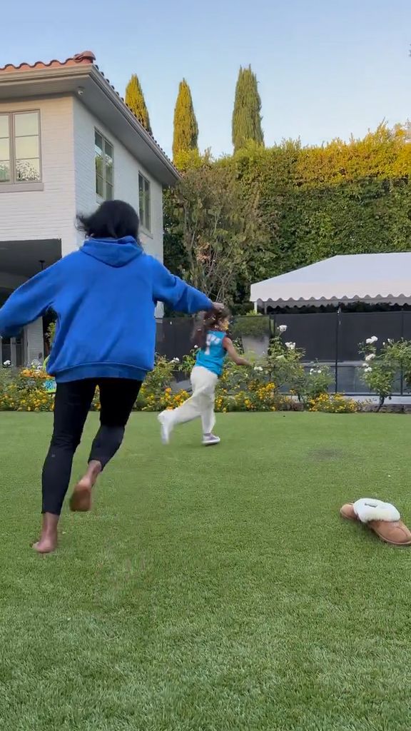 Mindy Kaling running after her daughter in the garden