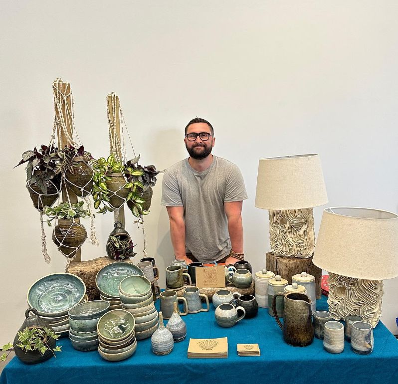 A man at a stall selling pottery