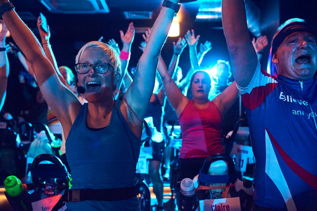 Group of people cheering in a spin studio