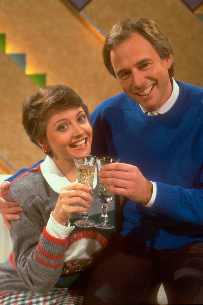 Television presenters Anne Diamond  and Nick Owen, co-hosts of Make A Date, celebrating with glasses of champagne, circa 1987