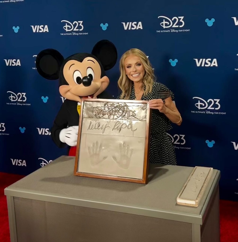 Photo shared by LIVE with Kelly & Mark on Instagram of Kelly Ripa posing with Mickey Mouse at the D23 Disney Legends Event