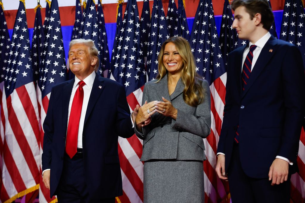 Republican presidential nominee, former U.S. President Donald Trump reacts on stage with former first lady Melania Trump and Barron Trump during an election night event at the Palm Beach Convention Center on November 06, 2024 in West Palm Beach, Florida. 