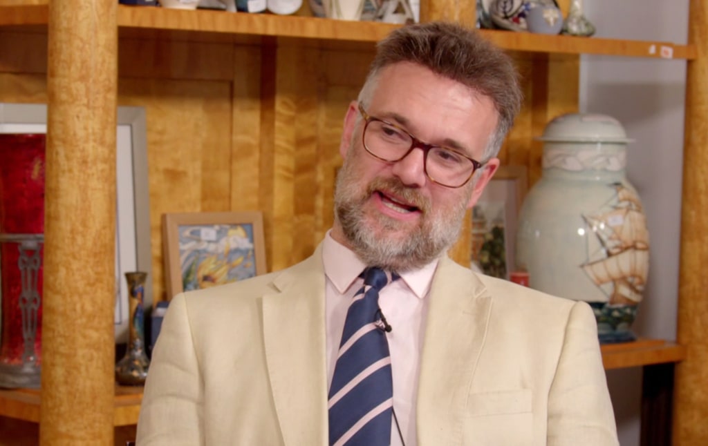 man in white suit with glasses