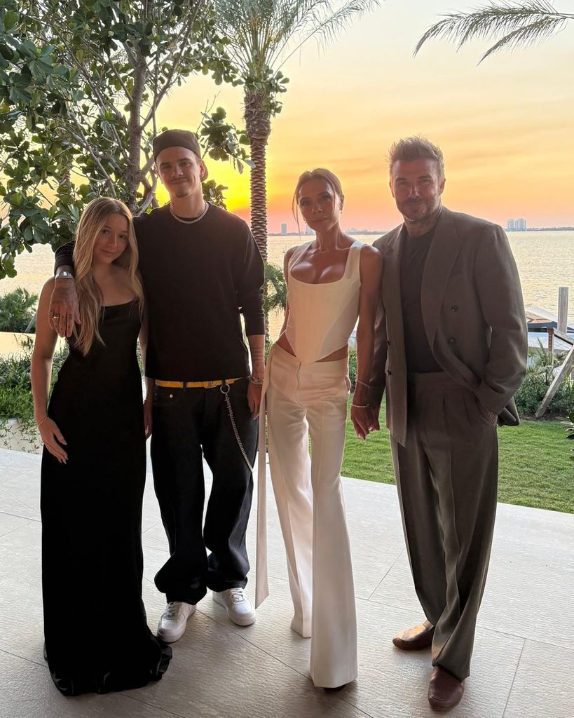 family posing against sunset