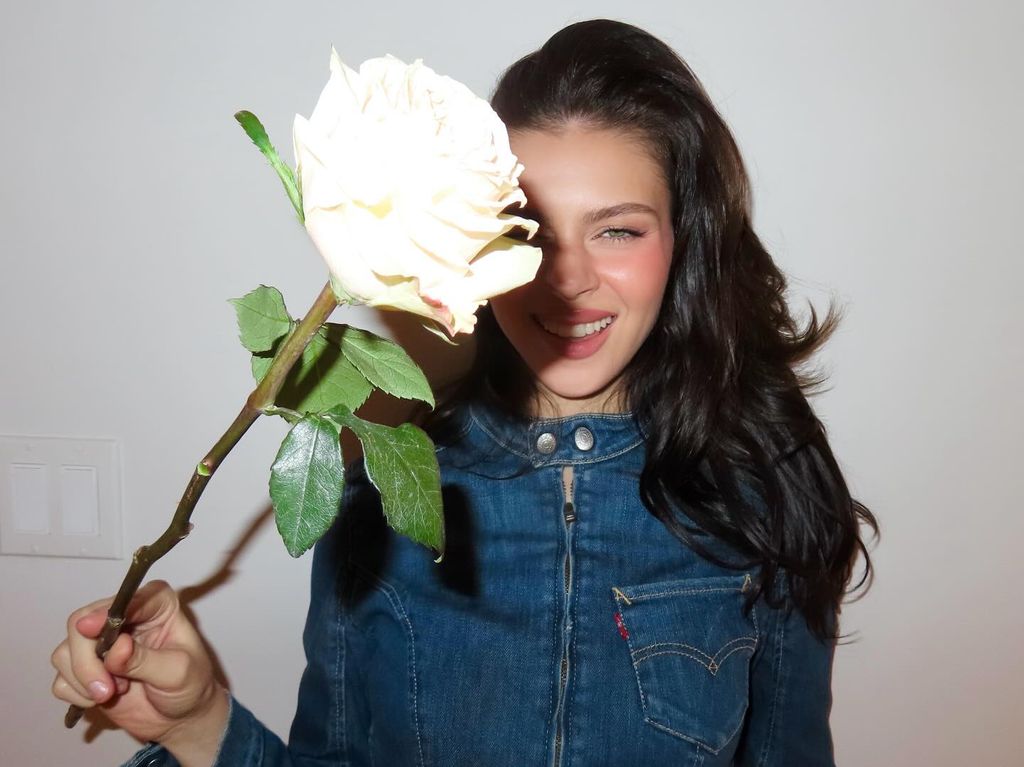 Nicola poses with a rose that her husband Brooklyn Beckham bought her