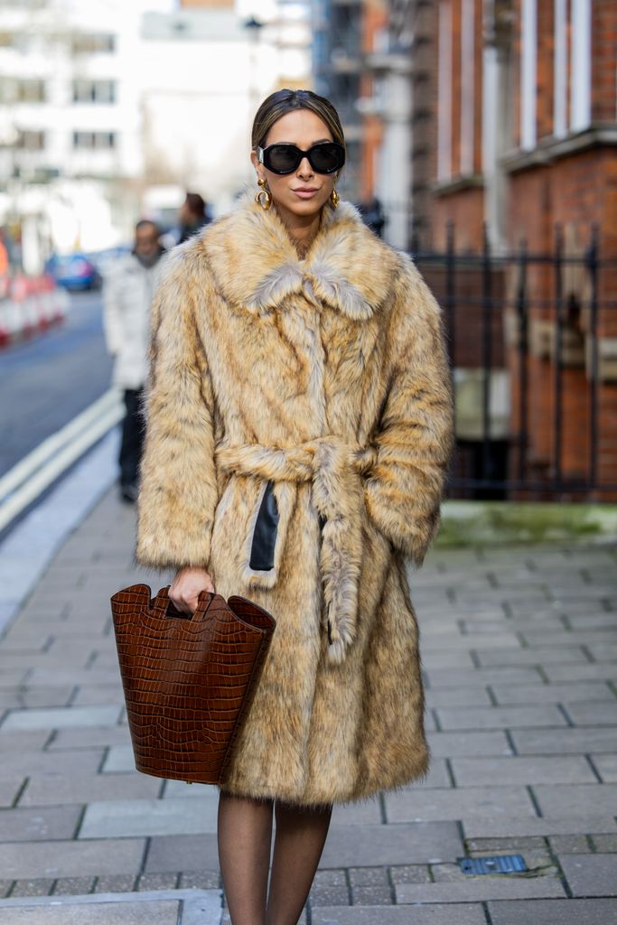 Isabella Charlotta Poppius  wears belted beige fur coat, brown bag, tights, sunglasses outside Bora Aksu during London Fashion Week February 2024 on February 16, 2024 in London, England. (Photo by Christian Vierig/Getty Images)