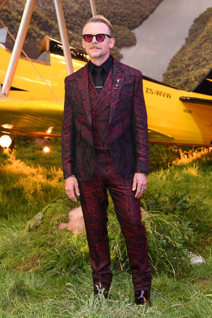 man in red suit by yellow plane