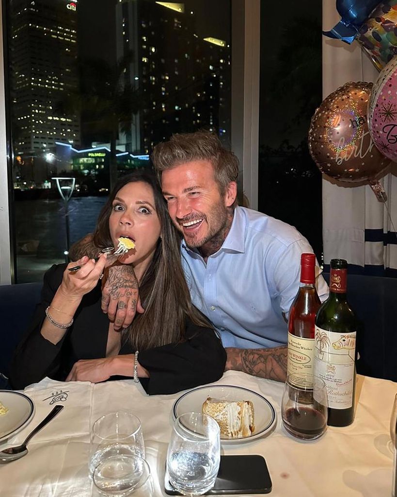 Victoria Beckham eating cake beside her husband David Beckham