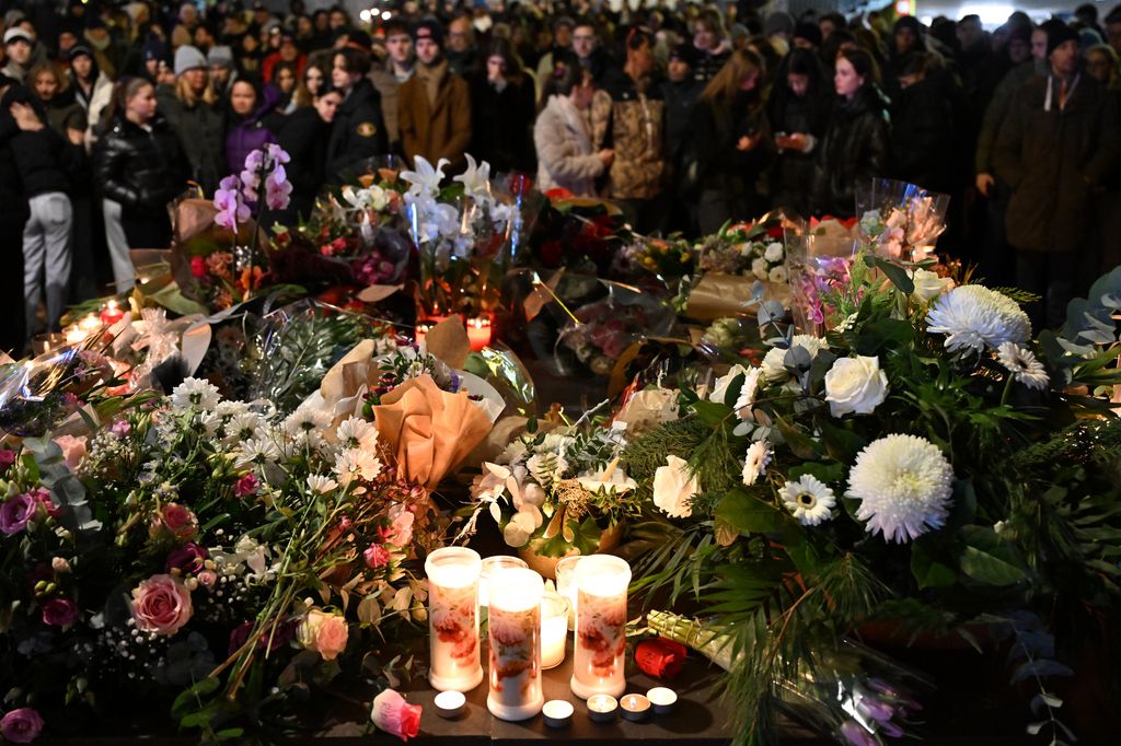 Mourners gather to leave flowers and candles at the scene after a fire broke out overnight at Le Constellation bar on January 01, 2026 in Crans-Montana, Switzerland