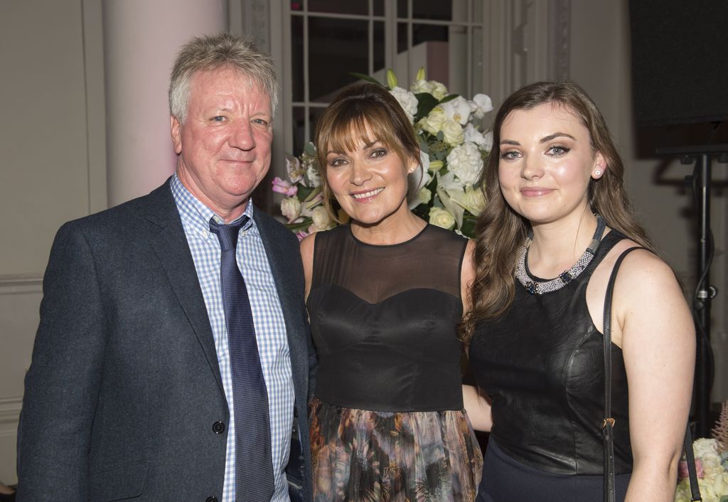 Lorraine Kelly and her husband Steve against the backdrop of white flowers