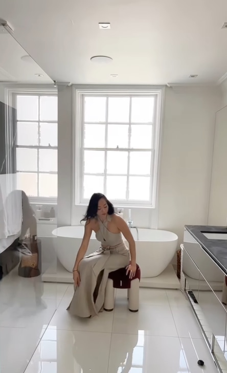 Dara Huang in white bathroom with sash windows