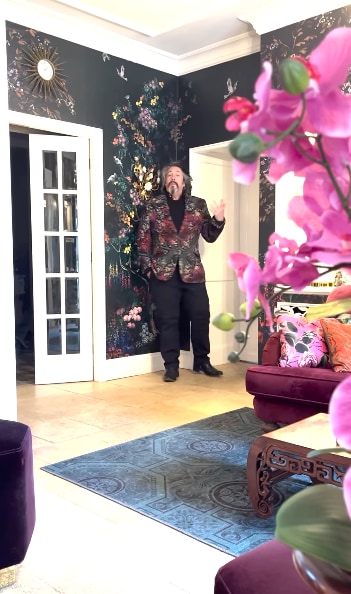 man in floral jacket in floral living room