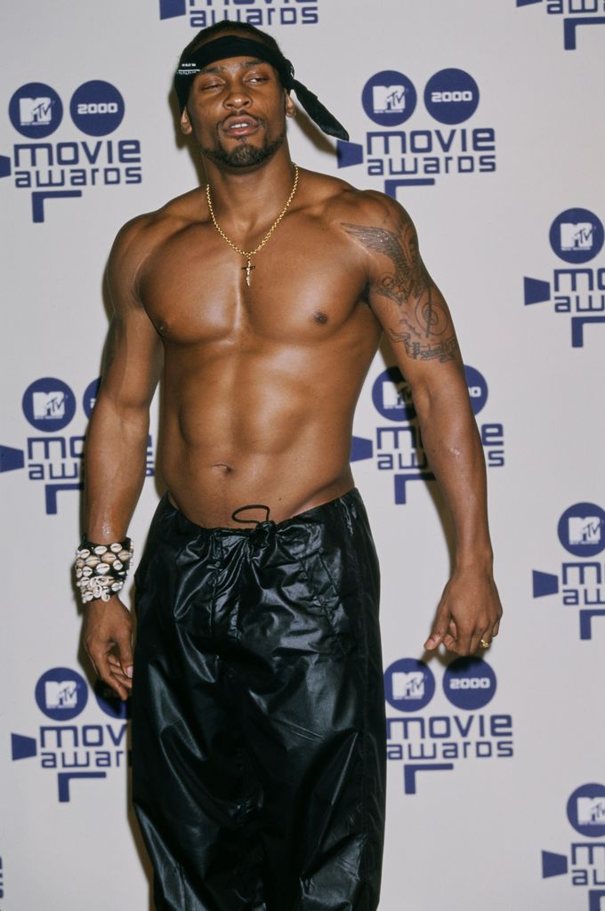 American singer and songwriter D'Angelo, shirtless with a black headband and black trousers, in the press room of the 2000 MTV Movie Awards,