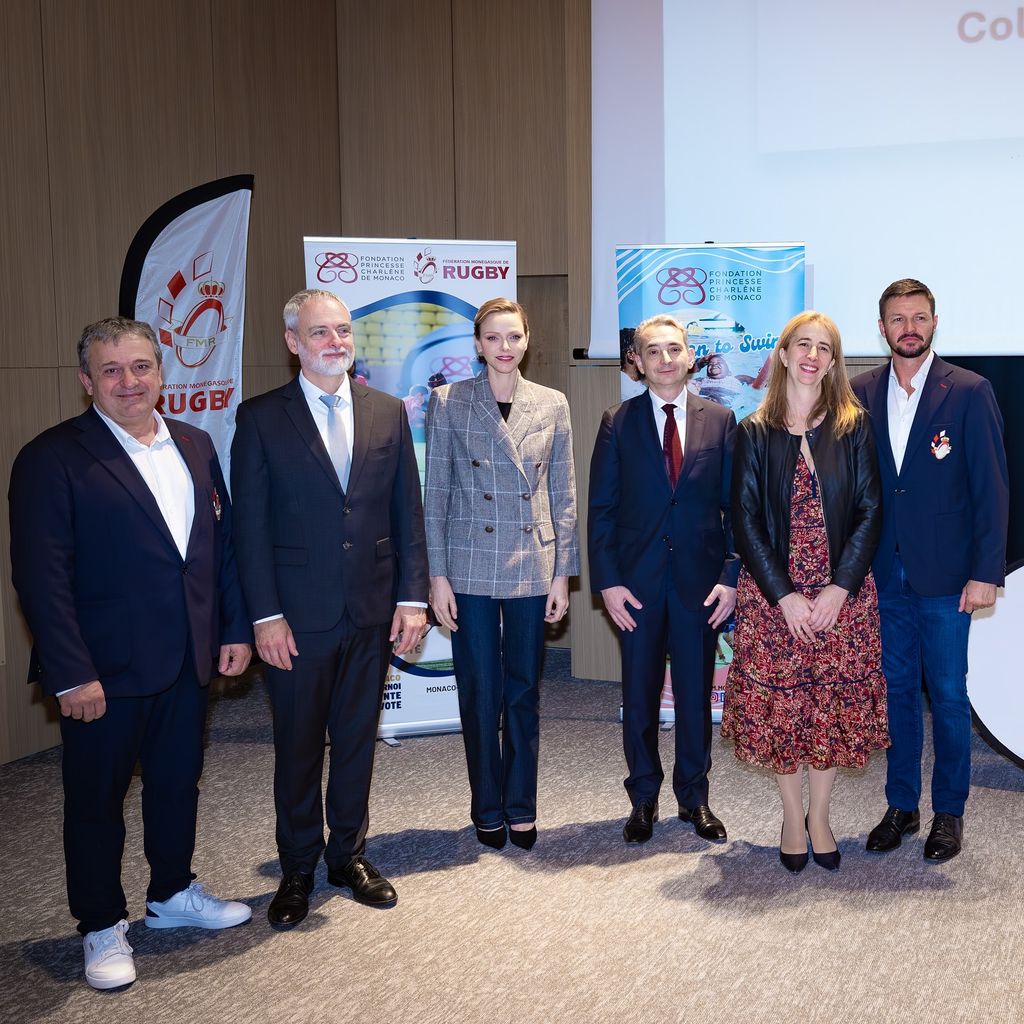 Princess Charlene in checked blazer in line of people