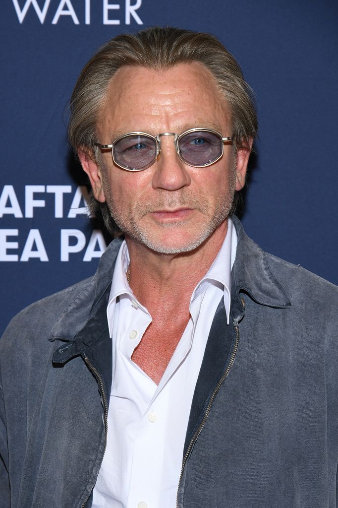 actor with long hair and blue glasses on red carpet