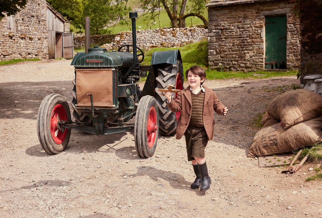 A little boy by a tractor