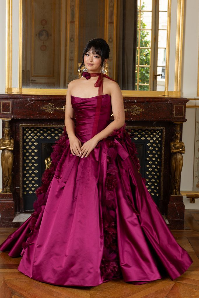 Alice Wang posed in magenta gown in front of fire place