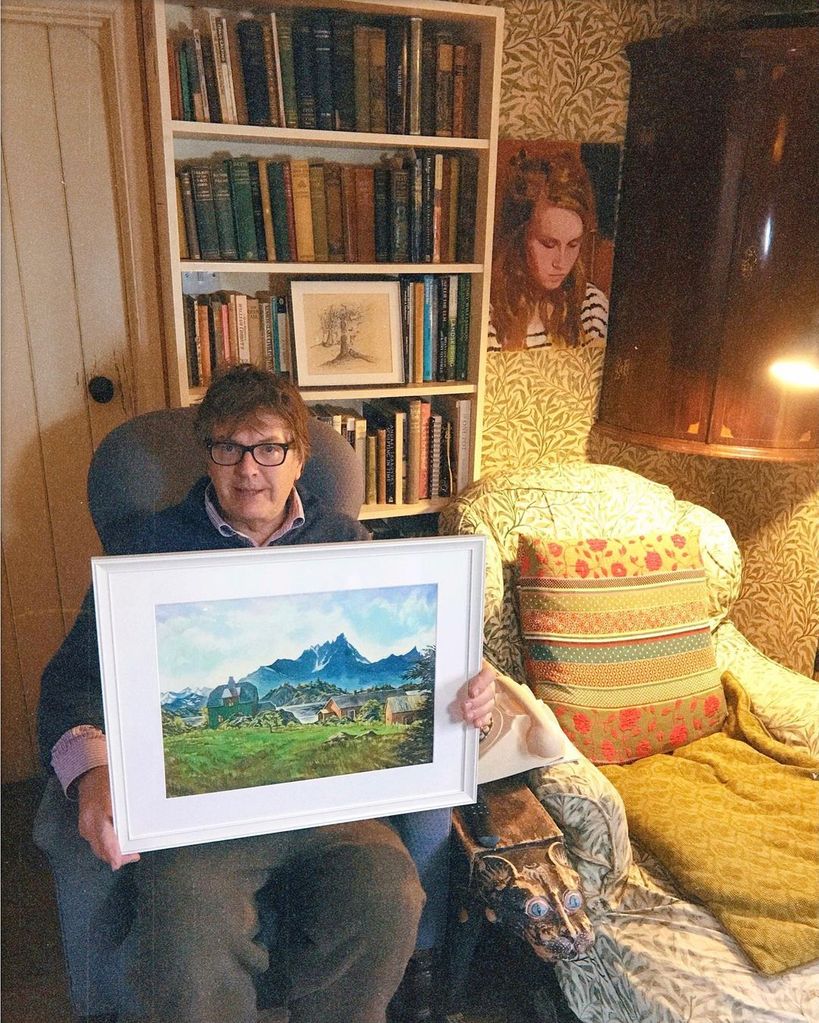 Gogglebox star Giles holding a painting on the sofa