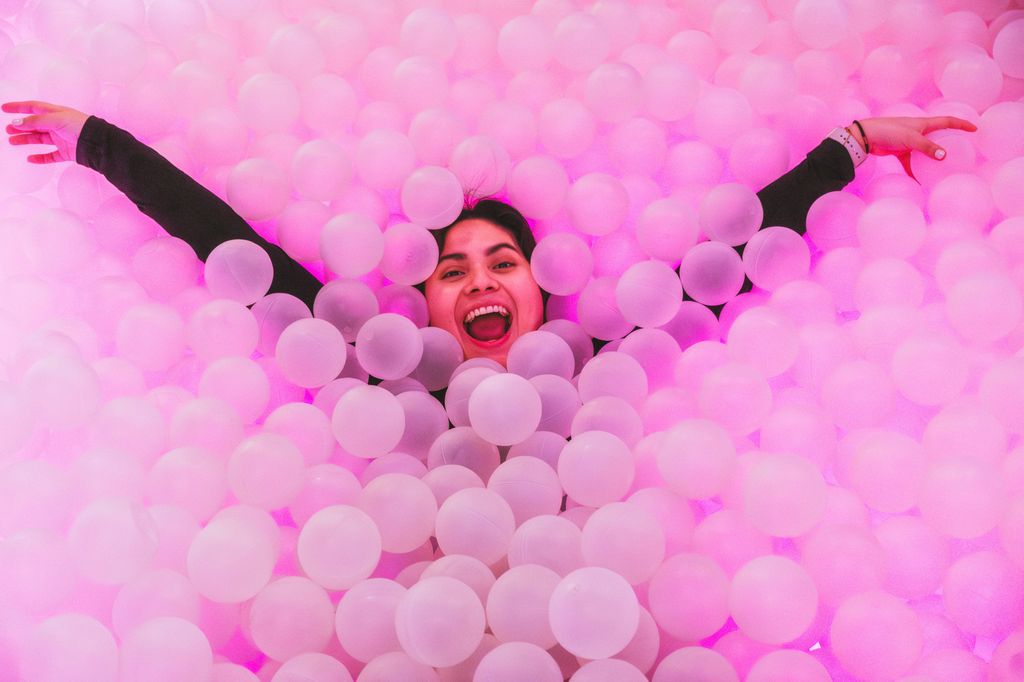 woman having fun submerged in a cool plastic ball pool.