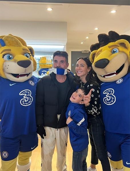 Simon Cowell with Lauren Silverman and son Eric with two lion mascots
